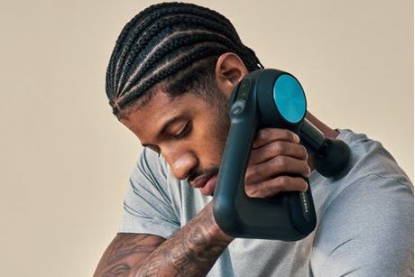 Massage musculaire des trapèzes avec un pistolets de massage pour sportifs