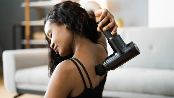 Utilisation d’un pistolet de massage pour détendre les lombaires et dorsaux