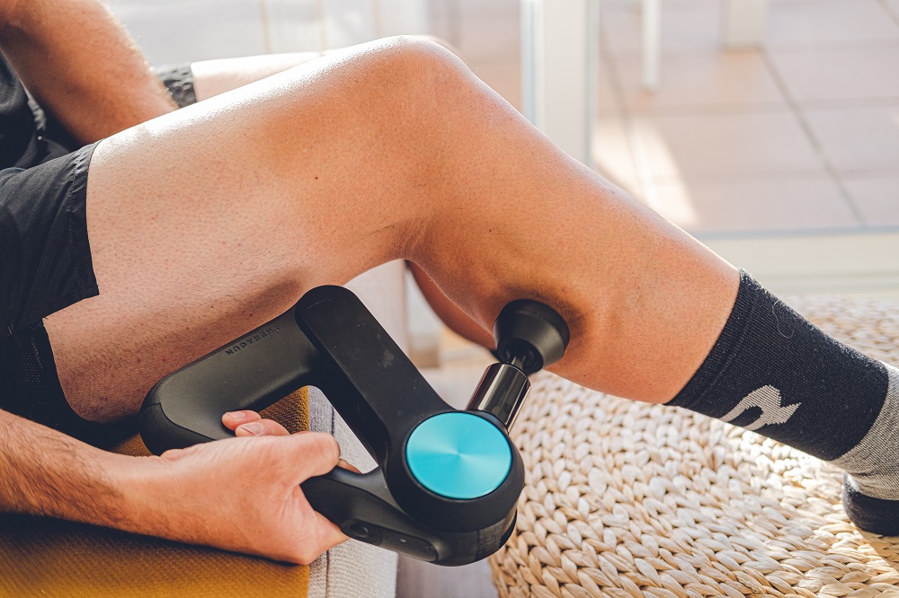 Utilisation d’un pistolet de massage sur les mollets après une séance de sport intense